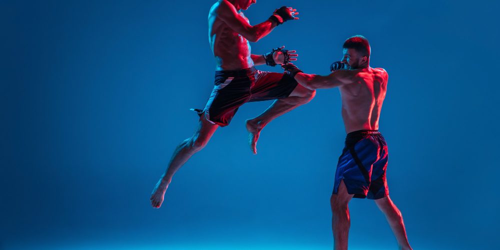mma-two-professional-fighters-punching-boxing-isolated-blue-wall-neon