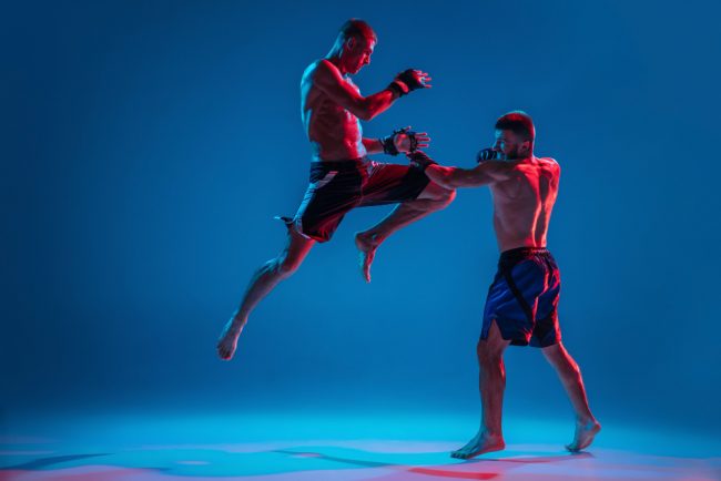 mma-two-professional-fighters-punching-boxing-isolated-blue-wall-neon