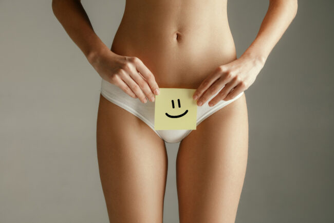 woman-health-female-model-holding-card-near-stomach-young-adult-girl-with-paper-sign-symbol-smile-isolated-gray-background