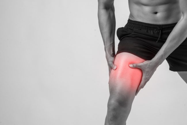 young-sport-man-with-strong-athletic-legs-holding-knee-with-his-hands-pain-after-suffering-ligament-injury-isolated-white