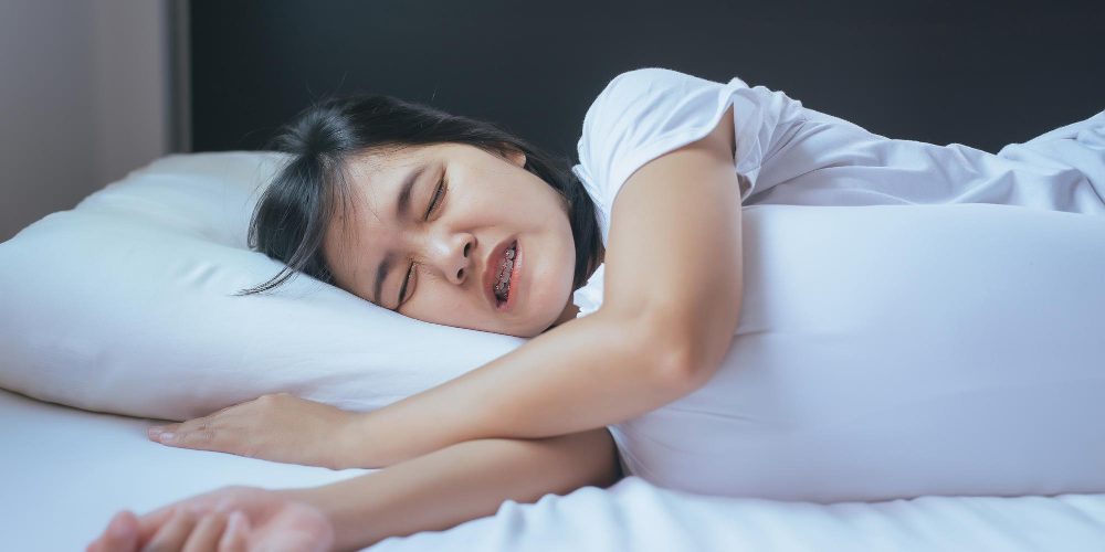 woman-sleeping-bed-grinding-teethtiredness-stress
