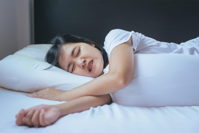 woman-sleeping-bed-grinding-teethtiredness-stress